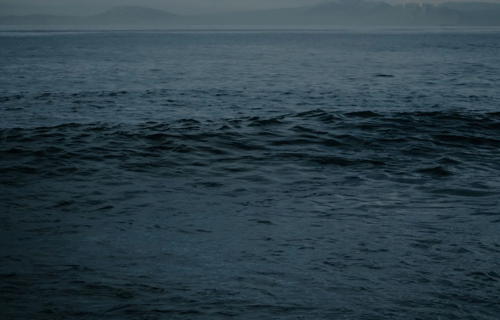 Dark ocean waves under a dim sky