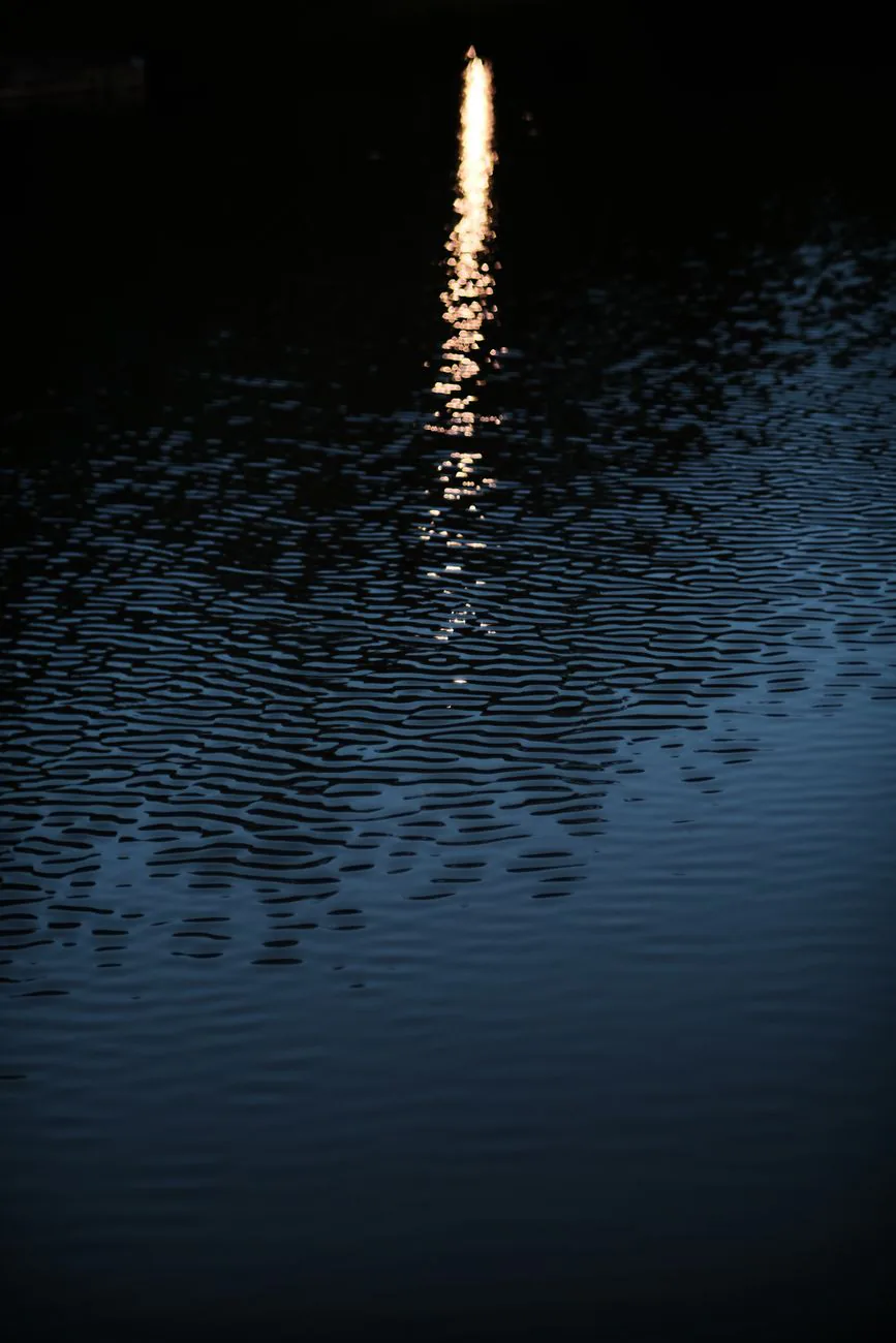 Soft light rippling across dark water at night