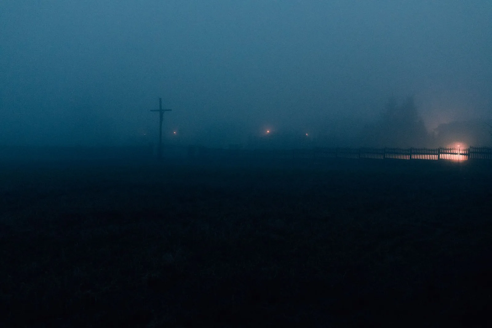Fog rolling over a dark landscape at night
